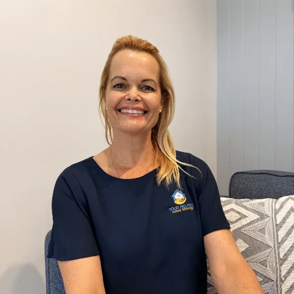 Kris Aitken, founder of Your Helpers, smiling, in a navy Your Helpers shirt